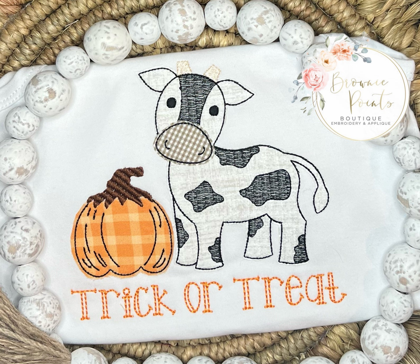 Cow with pumpkin appliqué