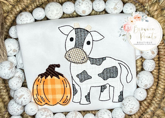 Cow with pumpkin appliqué